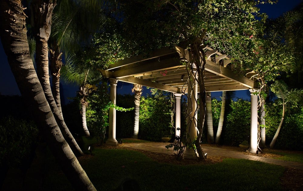 AMP® Spotlights illuminate a backyard pergola