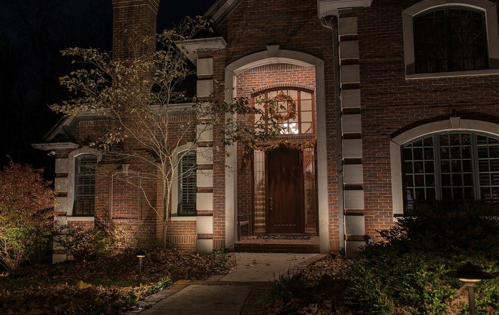 Illuminated brick home using AMP® Lighting spotlights and path lights